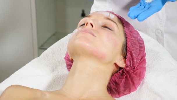 Mujer recibiendo tratamiento cosmético en el salón de spa. Cosmetólogo en guantes médicos aplicando mascarilla de belleza. Concepto de cuidado de la piel. hd — Vídeo de stock