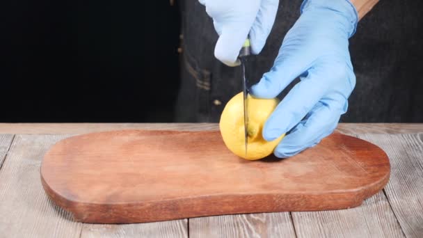 Chef dalam sarung tangan mengiris lemon di papan potong kayu. Restoran makanan cooing. Gerakan lambat. hd — Stok Video