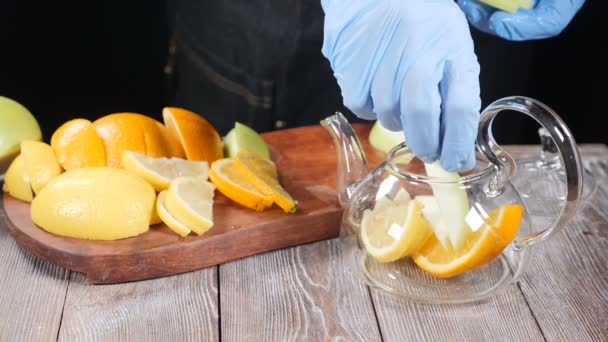 Preparar té de frutas frescas. Variedad de frutas en rodajas que se ponen en la tetera. Hacer bebidas saludables. En cámara lenta. hd — Vídeo de stock