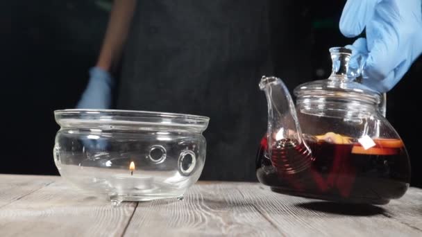 Théière en verre avec thé aux fruits étant mis sur brûleur dans le café. Ferme là. Au ralenti. hd 