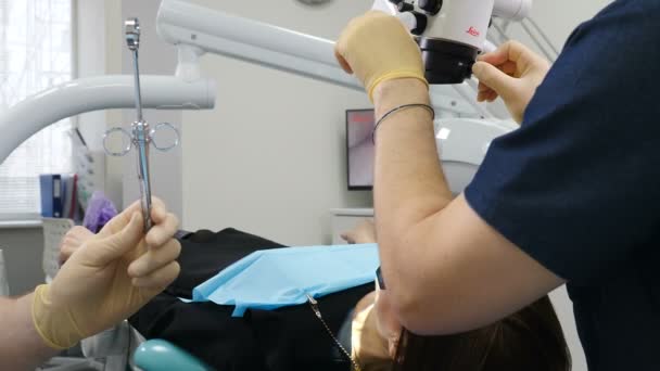 의학, 치과 의사 및 건강 관리 개념. 조수는 치과 의사에게 주사기를 제공합니다. 닫아. 마취와 인젝터를 준비. 치과 에서 환자 근처 의사와 조수. 4k — 비디오
