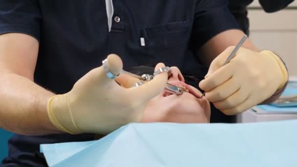 O dentista injeta um anestésico local nas gengivas. O dentista masculino faz anestesia dentária. Não há conceito de dor. Medicina e conceito de saúde, procedimento odontológico em consultório odontológico moderno. 4k — Vídeo de Stock