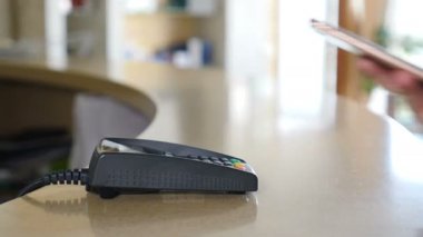 Nfc teknolojisini kullanarak akıllı telefonla ödeme yapan kadın müşteri. Close. Akıllı telefon ile temassız ödeme. Kredi kartı terminalinde akıllı telefon cihazıyla ödeme yapmak. Kablosuz ödeme. 4k.