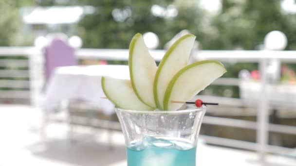 Slowmotion Shot av bartender i uteservering terrass som serverar en sommar cocktail med frukt. Knäckt isbitar faller i ett glas. Mat video. kost-och dryckes koncept. Hd — Stockvideo