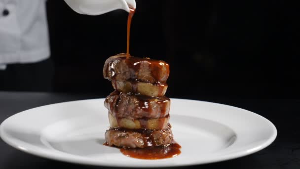 Відео про їжу у повільному русі. Шеф-кухар наливає соус на сковорідку. Ресторанна м'ясна страва. Гриль копчена телятина барбекю з плаваючим соусом у повільному русі. частина 3. HD — стокове відео