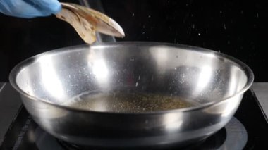 Yavaş hareket edilen foodvideo. Aşçı tava üzerinde midye yemek. Kavrulmuş midye yakın. Izgara deniz ürünleri. Yağ sıçraması. Hd