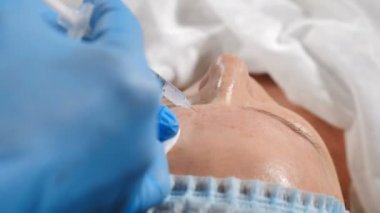 Modern güzellik konsepti. Genç kadın yüz enjeksiyon alma Doktor görünümü. Modern güzellik kliniğinde kadın müşteri yüz kırışıklık düzeltmesi alınıyor. Cerrahi olmayan Antiaging prosedürü. Güzellik enjeksiyon