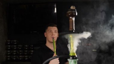 Hookah Bar. Adam sigara Shisha ve duman exhaling. Vape. Yavaş hareket. Kafkas harika adam Duman üflüyor. Sihirli sanat sis, kötü alışkanlığının kavramı. yavaş hareket. Hd
