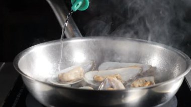 Yavaş hareket güzel yemek video. Restoranda aşçı tarafından deniz ürünleri pişirme. Italyan deniz ürünleri makarna flambe hazırlamak karides kullanarak, Istiridye, çanak midye. İtalyan mutfağı konsepti. Hd