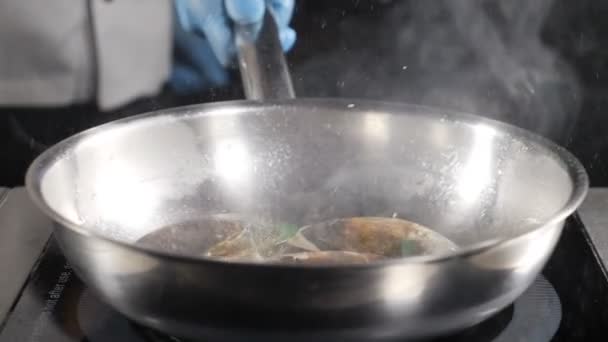 Esplêndido vídeo de comida em câmara lenta. chef cozinhar ou joga frutos do mar na frigideira. Salpicos de óleo. hd — Vídeo de Stock