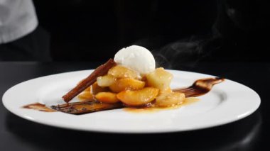 Restoranda lezzetli bir tatlı. Şef çikolata serpin. karamel soslu meyveli dondurma. Flambe çanak profesyonel şef tarafından pişirilir. Açık mutfak gösterisi. Yavaş çekim. Hd