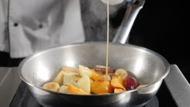 Ο σεφ ρίχνει γλυκιά ζαχαρένια καραμέλα πάνω από τα φρούτα στο τηγάνι. Μαγείρεμα νόστιμο επιδόρπιο. Το βίντεο του φαγητού σε αργή κίνηση. Hd — Αρχείο Βίντεο