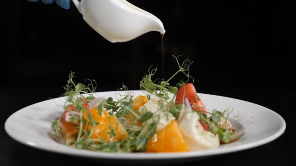 Un bon concept alimentaire. Salade de légumes santé avec vinaigrette à l'huile d'olive. Gros plan du chef tenant un pot blanc avec de l'huile d'olive. Cuisine de salade dans la cuisine du restaurant. Au ralenti. Hd — Video