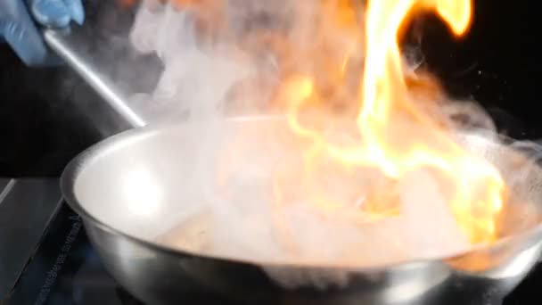 Unbekannter Koch wirft heiße Antihaft-Pfanne mit Meeresfrüchten und setzt sie dann in Brand, um Flammengericht zu kochen. Zeitlupentempo. hd — Stockvideo