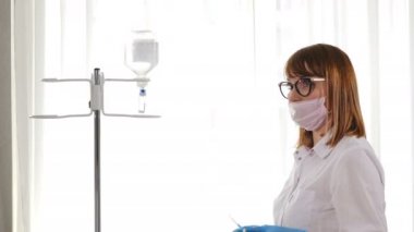 Hafif ameliyathanede intravenöz damla ayarlama, infüzyon damlama. Ameliyathanede ameliyathanede cerrah ameliyathanesi. Tıbbi IV Düşme Oranı. tıbbi damlalık profesyonel kadın doktor tarafından ayarlanan