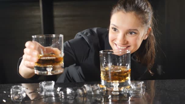 Bar et concept de cocktail. Femme barman en uniforme noir souriant à la caméra tout en faisant des cocktails. Concept de vie nocturne. Au ralenti. Au ralenti. Les lunettes sont au point. hd — Video