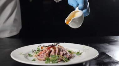 Restoran mutfağında aşçı yemek yapıyor. Şeftali ve mutfak bitkileri ile lezzetli sos flambe kızarmış ördek eti dökme. Güzel yemekler. Yavaş çekim. Hd