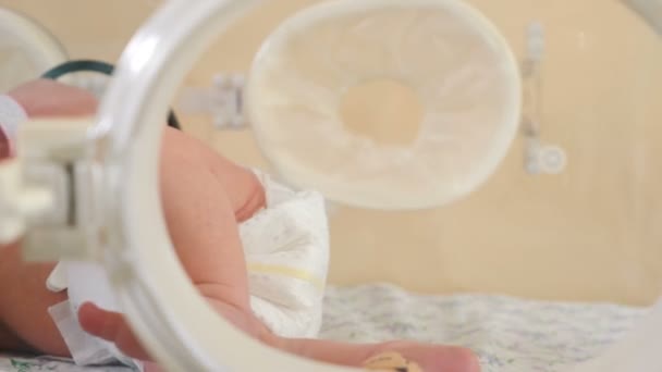 Concepto de salud infantil. pies de un bebé recién nacido en el hospital. incubadora para un bebé prematuro en una ambulancia de reanimación. Terapia intensiva couveuse de un bebé recién nacido. Equipos médicos en maternidad — Vídeos de Stock