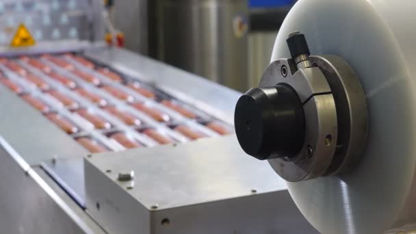 Las manos de los trabajadores ponen salchichas frescas en bandejas para envasado al vacío. Embalaje al vacío de carne procesada. Industria cárnica. 4k — Vídeos de Stock