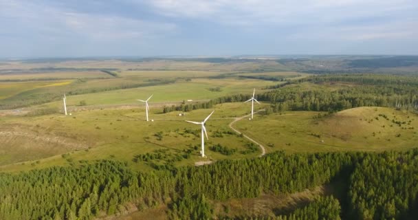 Aerial Shot av vindkraftverk roterande med kraft av vinden och generera förnybar energi. Naturvänlig energi i Ryssland. Tre moderna väderkvarnar som arbetar på fältet i slutet av sommaren. 4K — Stockvideo