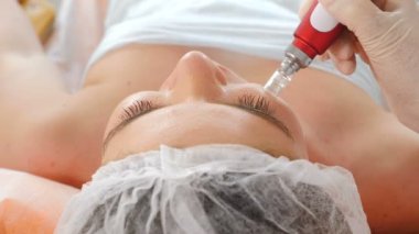 Profesyonel kozmetoloji uzmanı Dermapen işlemini akozmetoloji kliniğinde gerçekleştirmektedir. Güzellik konsepti. Yüz kozmetik prosedürü. 4 k'da çekilmiş