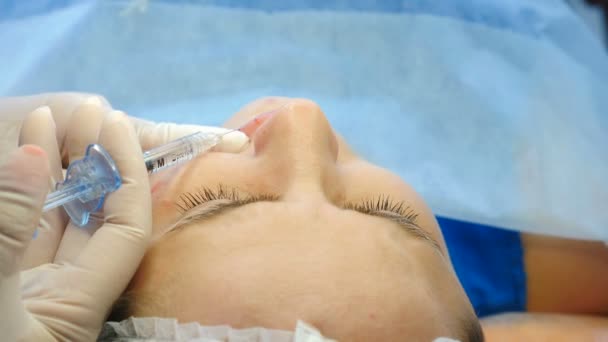 Młoda kobieta w klinice kosmetycznej przed zastrzykami kosmetycznymi. Kosmetolog oznaczający iniekcję twarzy w klinice medycznej. Zabieg iniekcji twarzy i anti aging dla skóry młodej i pięknej. 4k — Wideo stockowe