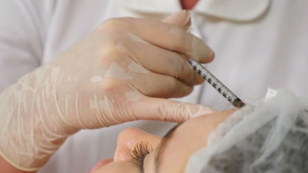 Cosmeticus in handschoenen die face lifting injectie in het gezicht maakt. vrouwelijke cliënt krijgt gezichtsbehandeling schoonheidsbehandeling in de gezondheidszorg kliniek. . collageen. Schot in 4k. — Stockvideo