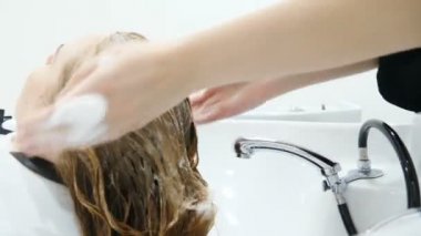 Güzellik stüdyosu. Kadın saçını şampuanla, makyajla ve güzellik salonuyla yıkamak. Saç yıkayan kuaförün elini kapat. Saç bakımı kavramı. Hd