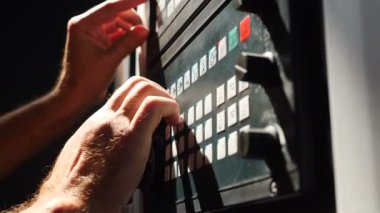 Endüstriyel ekipmanlardaki düğmelere basan erkek elleri yakın çekim. Otomatik üretim hattını kontrol eden mühendis. Makine kontrol paneli üzerinde çalışan bir fabrika uzmanı. 4k