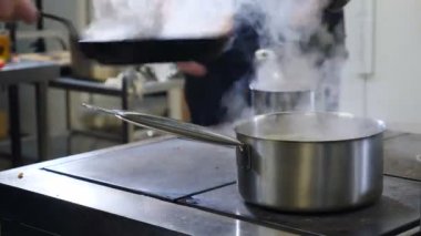 Restoran mutfağı konsepti çok yoğun. Aşçılar ve mutfak personeli ticari mutfakta yemek hazırlayıp servis ediyor. Acele et. Kapatın. Fırlatmak, sosis dökmek ve kızartma tavasına dönmek. 4K 'da çekilmiş.