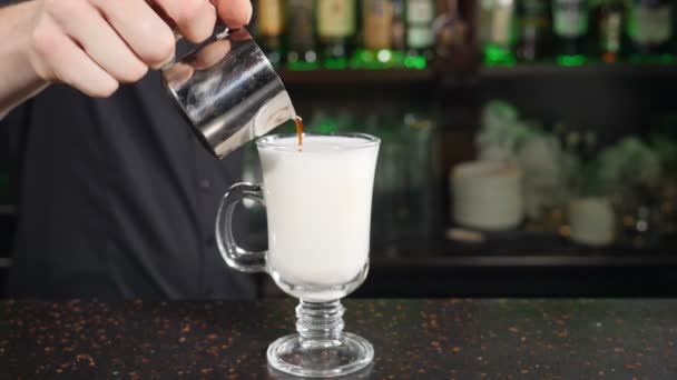 Barista häller espresso i genomskinligt glas och gör latte. Sakta i backarna. Kaffe gör koncept. Bartenderyrke i baren. Skjuten i hd — Stockvideo