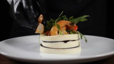 Mozzarella, mikro yeşillik, domates ve karidesli restoran imzalı salata. Şef, restoranın mutfağında pişmiş taze vejetaryen aperatifine haşlanmış karides ekliyor. Ağır çekim. Tam Hd