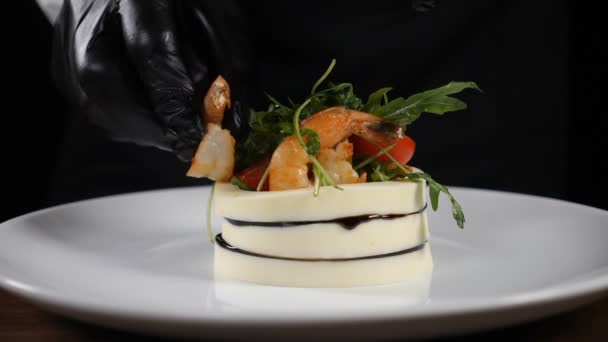 Restaurante ensalada de autor con mozzarella, micro vegetación, tomate y camarones. Chef terminando el plato añadiendo gambas hervidas al aperitivo vegetariano fresco cocinado en la cocina del restaurante. En cámara lenta. Full hd — Vídeo de stock