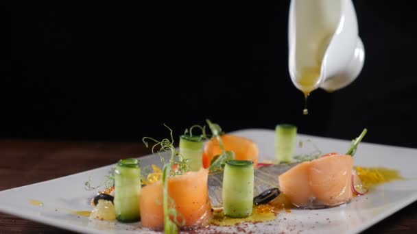Slow motion food video in restaurant. Close-up shot van chef-kok gieten extra vergine olijfolie op vis snack geserveerd met groenten. Gesneden haring op een witte plaat. Vol hd — Stockvideo