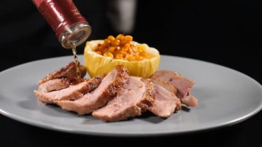 Yavaş çekimde yemek görüntüsü. Et ve fırında pişmiş balkabağı ile imza yemeği. Restoranda beyaz tabakta servis edilen dilimlenmiş etin üzerine konyak dökmek. Tam Hd