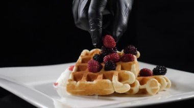 Tatlı kahvaltı servisi, sağlıksız yemek. Şeker yiyecekler. Yanında dondurmayla waffle tabağının üzerine olgun böğürtlen koyarak. Ağır çekim dood videosu. Tam Hd