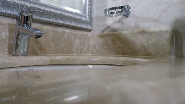 Hotel fürdőszoba. Közelkép elhelyezése fehér íjak zuhanyzóval zselé, sampon, fogkrém és kefe WC-asztalon a modern szállodában. Szobaszerviz, Tisztítási koncepció, 4 k videó — Stock videók