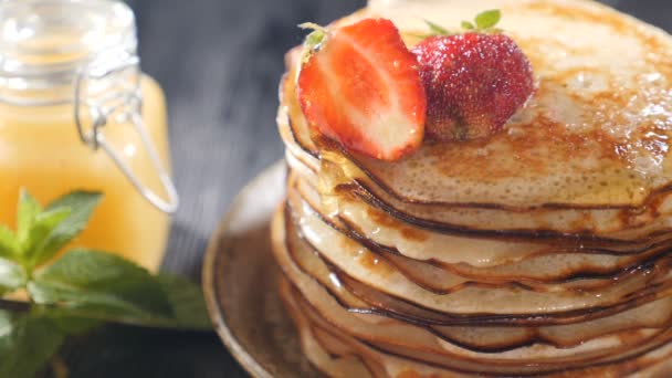 Stack of pancakes with fruits and berries on top. Honey dripping down on pancake stack. Slow motion. Food Pancake Maple syrup pouring onto stack of pancakes. Tasty and sweet breakfast. Full hd — Stock Video