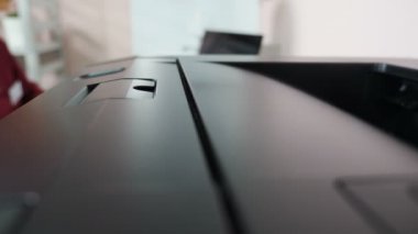 Yazıcı iş başında. Kağıt levha basılıyor. Yazıcıdan kağıt alan bir kadın. Siyah yazıcı makinesinin ofis ortamında dokümanların çıktısını alırken çekilmiş detaylı bir fotoğrafı. 4k video