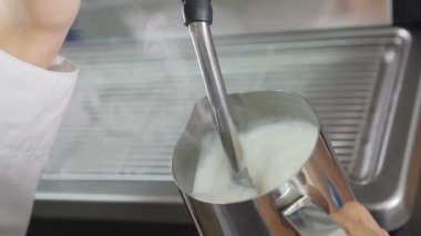 İş yerinde kahve makinesi var. Cappuccino için süt sallıyorum. Yavaş çekim yemek videosu. Espresso ve buharlı süt yapıyorum. Barista kahve evinde sıcak süt köpüğü hazırlıyor. Tam Hd