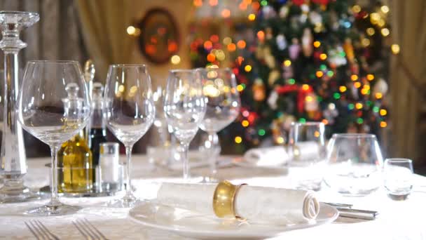Stół świąteczny serwowany na świąteczną kolację w salonie. Zimowy stół świąteczny serwowane, Nowy Rok drzewo miga. Uczta stołowa z serwetką. Świąteczne dekoracje. Koncepcja restauracji. 4 tys. wideo — Wideo stockowe