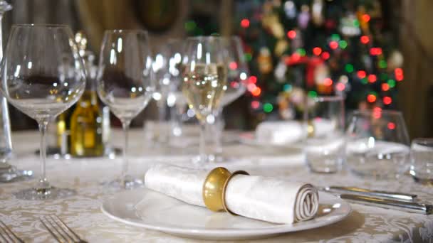 Koncepcja restauracji. Nowy Rok i wesołego świątecznego stołu. Kelner w rękawiczkach serwujący dania na stole w tle. Światła na drzewie migają. 4 k — Wideo stockowe