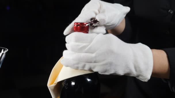 Foto en cámara lenta de las manos del camarero retorciendo la botella de apertura del cuchillo de vino. Disparo sobre fondo negro. Full hd — Vídeos de Stock