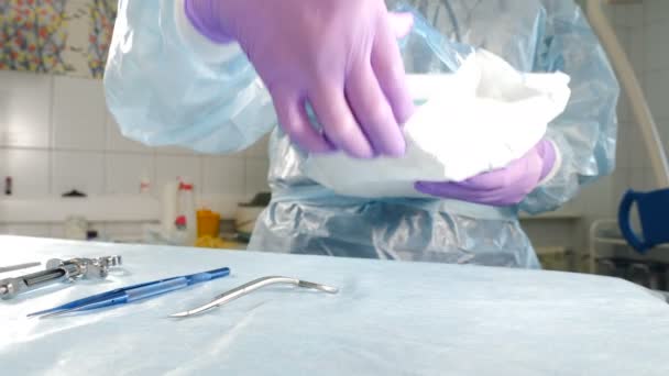 Assistent op het werk in de tandheelkundige kliniek. Chirurgische instrumenten worden voorbereid voordat implantatie op assistent tafel. Een close-up schot. 4 k video — Stockvideo