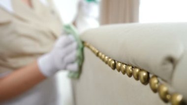 Otel temizliği. Yumuşak mobilya yüzeyi ve kadın eliyle silinen düğmeler. Kirli lekeleri temizleyen kadının yakın plan görüntüsü. Evde, dairede dezenfekte ediliyor. 4k görüntü