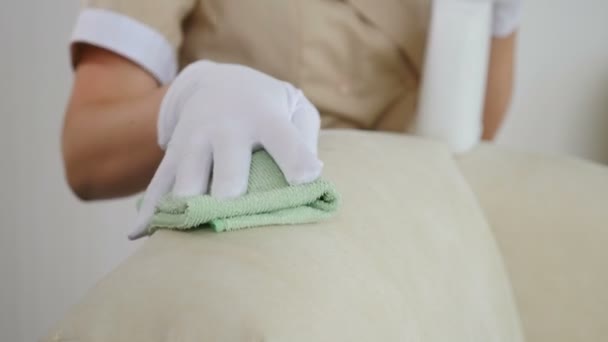 Pulizia dell'hotel. La superficie morbida della mobilia è pulita dalle mani femminili con il wipe. Vista ravvicinata della donna che rimuove la macchia sporca dai mobili imbottiti con un panno imbevuto di detergente. Disinfezione a casa — Video Stock