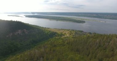 Rusya, Samara bölgesi. Samarskaya Luka Milli Parkı 'ndaki Zhiguli Dağları' nın yeşil ağaçları ve Volga Nehri 'nin havadan görünüşü. 4k görüntü