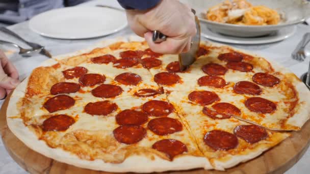 Cortar la pizza antes de servirla. Preparación de comida italiana en el restaurante. Primer plano de deliciosa pizza cortada en pedazos. pizza recién horneada. En cámara lenta. Full hd — Vídeo de stock