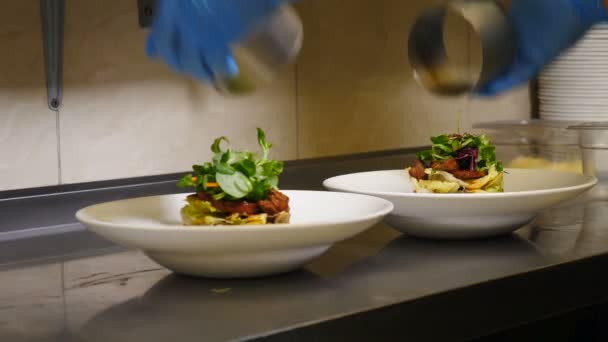 Vařím čerstvý salát. Šéf zvedá kulinářské kruhy. Koncept restaurace, kuchyňský pracovník v modrých rukavicích se chopí servírovacího nástroje. Shot in 4k — Stock video