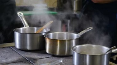 Restoran mutfağı konsepti çok yoğun. Aşçılar ve mutfak personeli ticari mutfakta yemek hazırlayıp servis ediyor. Acele et. Kapatın. Fırlatmak, sosis dökmek ve kızartma tavasına dönmek. 4K 'da çekilmiş.